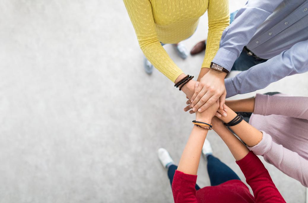 Les membres de l'équipe placent leurs mains sur le dessus des mains