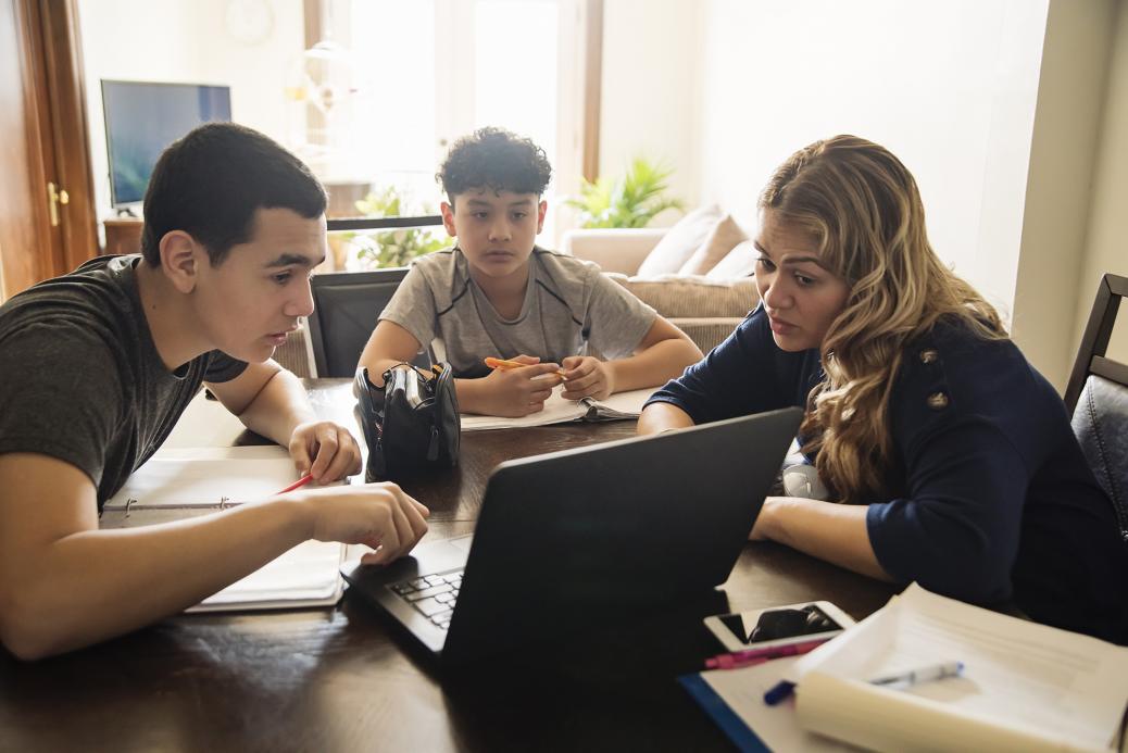 Une mère aide ses enfants à faire leurs devoirs