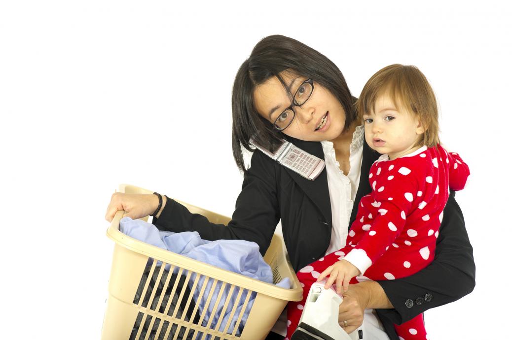 Mère tenant son bébé dans un bras et un panier à linge dans l'autre.