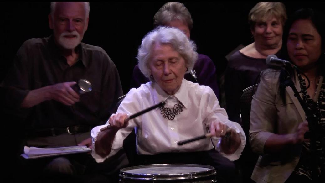 Une femme âgée qui joue le tambour