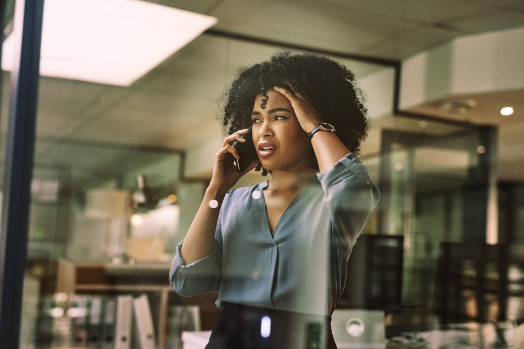 Femme au téléphone avec une expression de choc