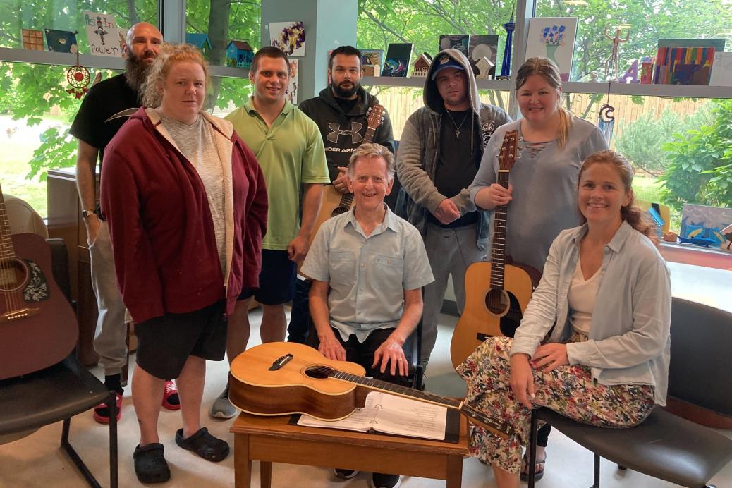 Un groupe de guitare met l’accent sur l’harmonie et la guérison Michael Fahey, musicien d’Ottawa (au centre), et Ashleigh McGuinty, récréothérapeute (assise à droite), avec certains membres du groupe de guitare du Royal.