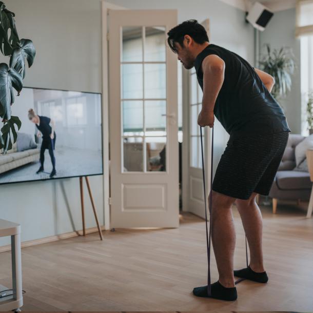 Un homme fait de l'exercice avec un programme à la télévision