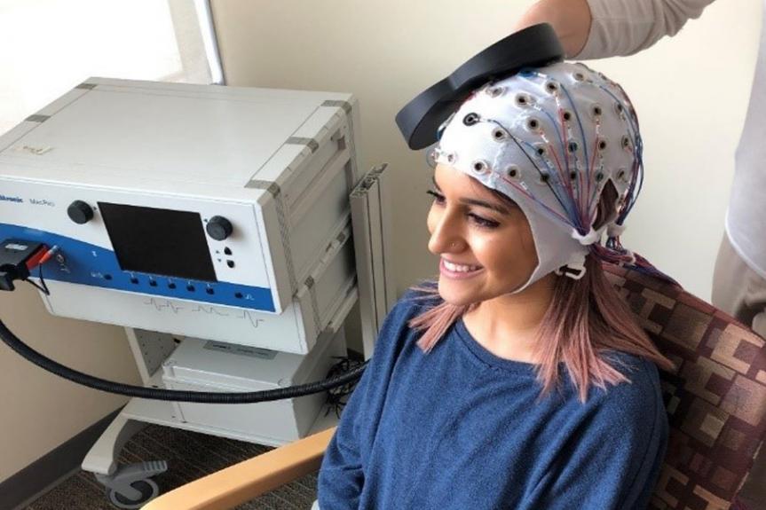 Une femme portant une casquette pour la stimulation magnétique transcrânienne répétitive (rTMS)