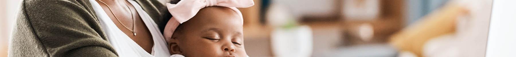 Tenir un journal périnatal comme outil de mieux-être Une maman écrit dans son journal avec son bébé sur les genoux.
