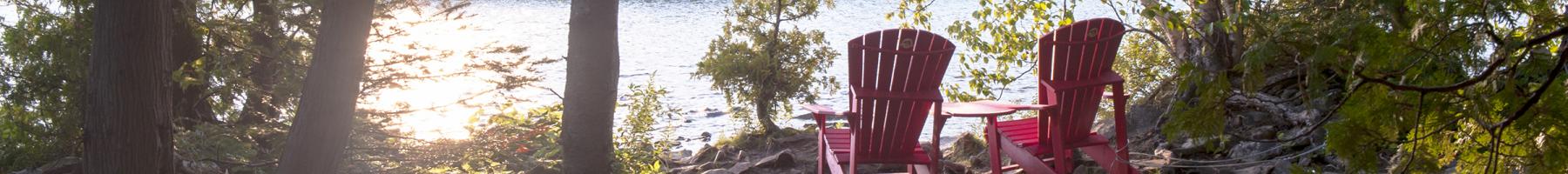 Évaluation et traitement sensoriels Cadre paisible dans les bois avec deux chaises vides regardant vers le lac.