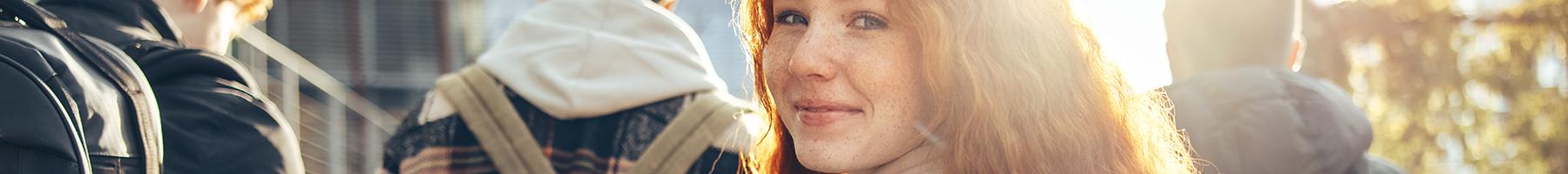 Let’s Talk, but how? Expert advice for talking to youth about their mental health Female student walking in group and glancing back while going to class in college.