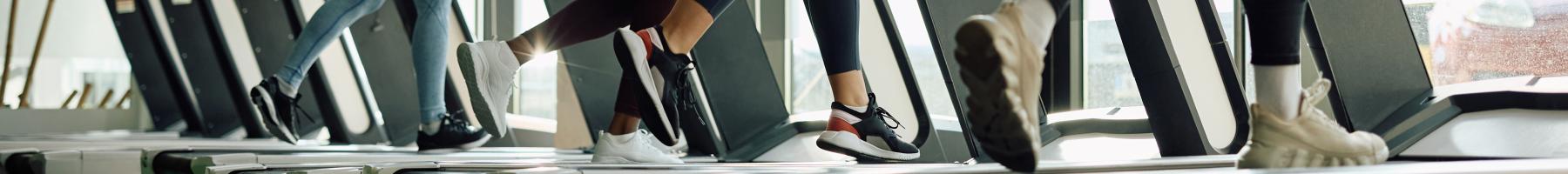 Gros plan de pieds sur un tapis roulant.