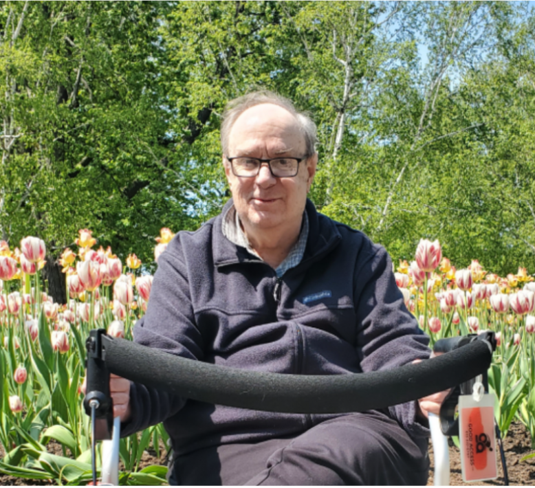 Richard sitting in front of tulip garden