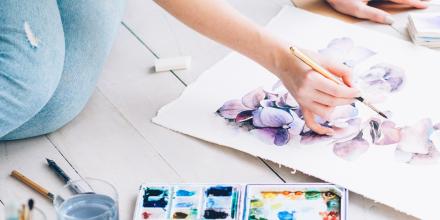 Person sitting on floor painting with watercolours